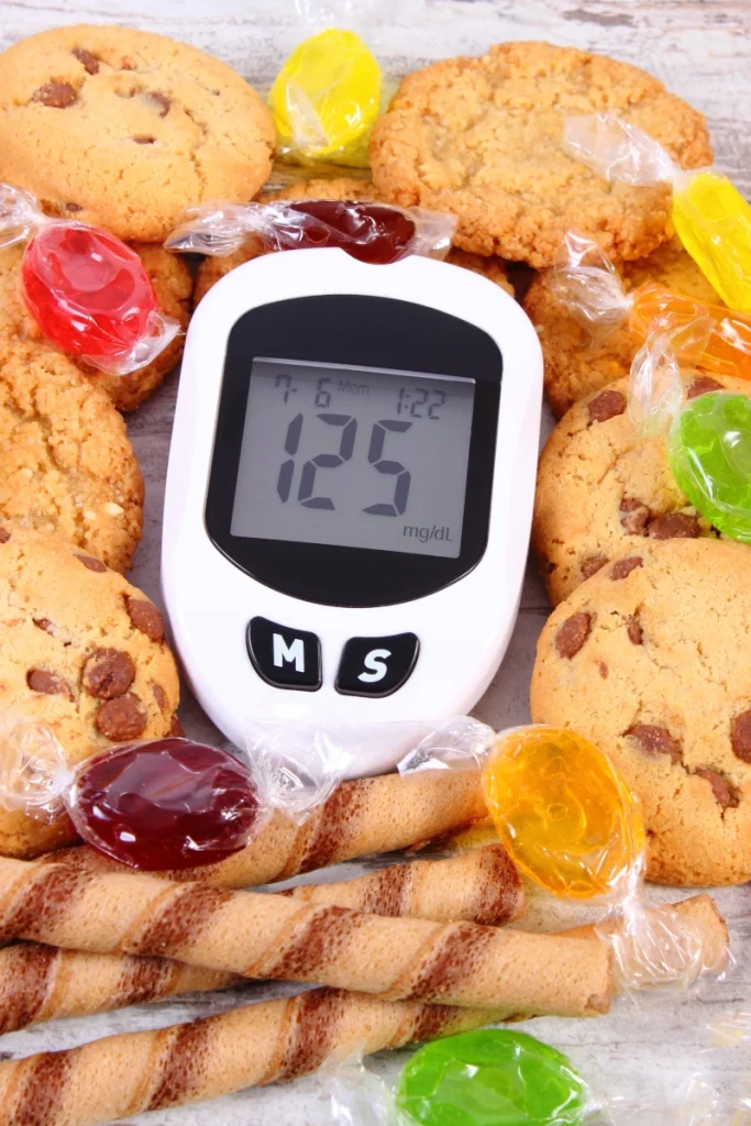 glukometr obok produktów zawierających duże ilości cukru (słodyczy)