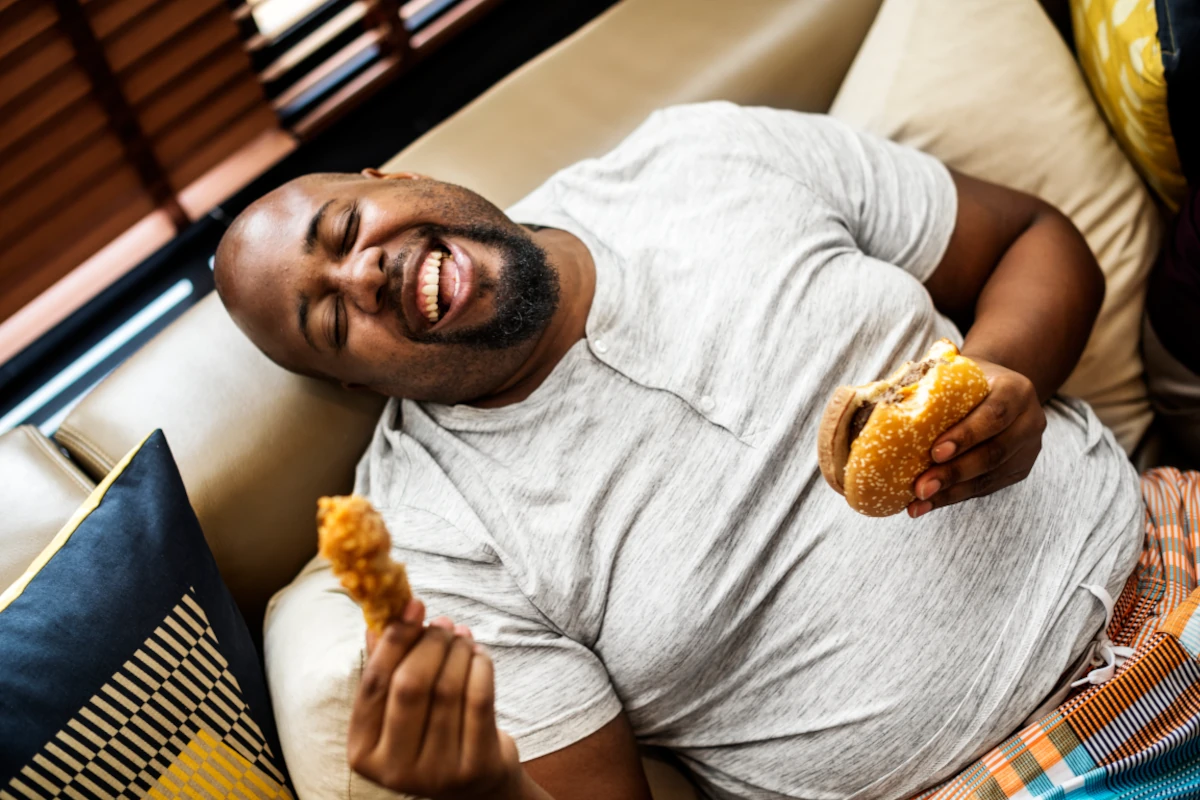 głodny pan z nadwagą który je zbyt szkodliwego hamburgera